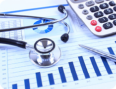 Pen, stethoscope, calculator atop printed graphs