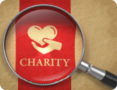 magnifying glass over a ribbon reading 'CHARITY'