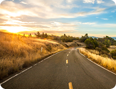 rural road disappearing into sunset