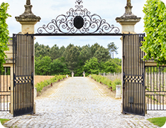 ornate gate and cobblestone driveway to estate