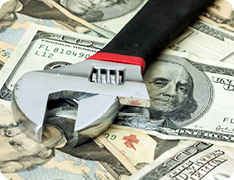 wrench resting on cash
