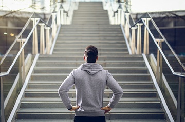 Man looking up steep flight of stairs