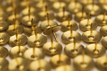 thumbtacks, one overturned