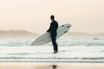 surfer on beach watching waves