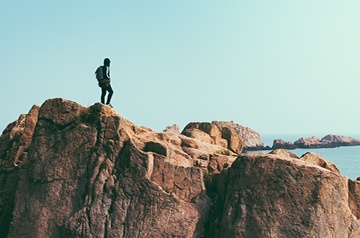 hiker standing on coastal rocks