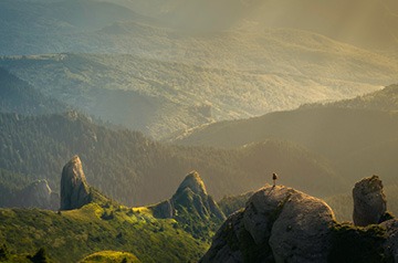 hiker viewing wooded valley below